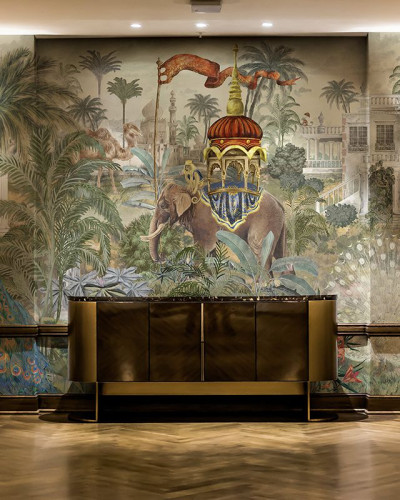 Tapet Empire Sanctum, un tapet pictural cu un elefant, o junglă luxuriantă și o casă luxoasă, adăugând o notă de opulență și unicitate decorului.