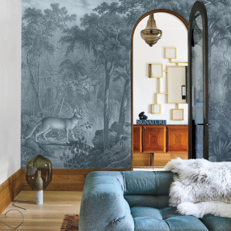Tapet cu design minimalist Jungle Cat Blue, cu imaginea unui leu ghemuit într-o junglă luxuriantă, într-o nuanță de albastru gri.