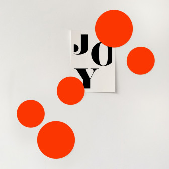 Magneți portocalii în formă circulară pe un perete alb