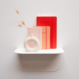 Poliță metalică albă cu vază și agende