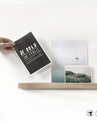 Raft magnetic din lemn de 45cm expunând fotografii și ilustrații.