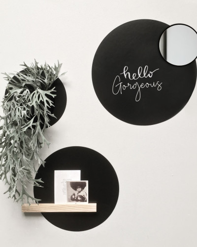 Set stickere magnetice rotunde negre pe perete alb, cu diverse obiecte decorative