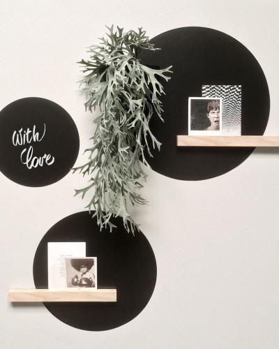 Set stickere magnetice rotunde negre pe perete alb, cu diverse obiecte decorative