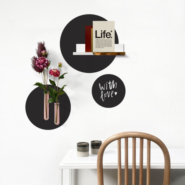 Set stickere magnetice rotunde negre pe perete alb, cu diverse obiecte decorative