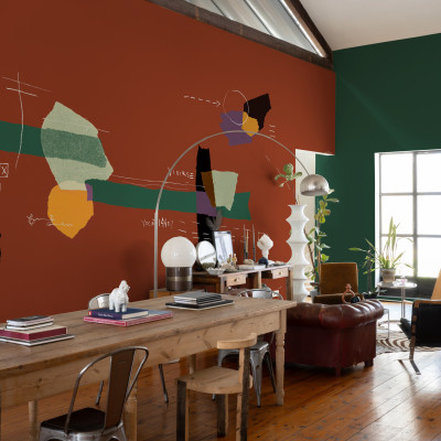 Tapet lavabil cu design abstract în nuanțe de roșu, verde, galben și mov. Tapetul este prezentat într-un interior modern, cu un canapea din piele, un fotoliu și o masă din lemn.