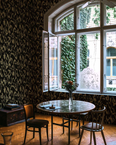 Tapet lavabil Moire Screen, negru, cu un model abstract inedit, decorand un perete accent din casa.