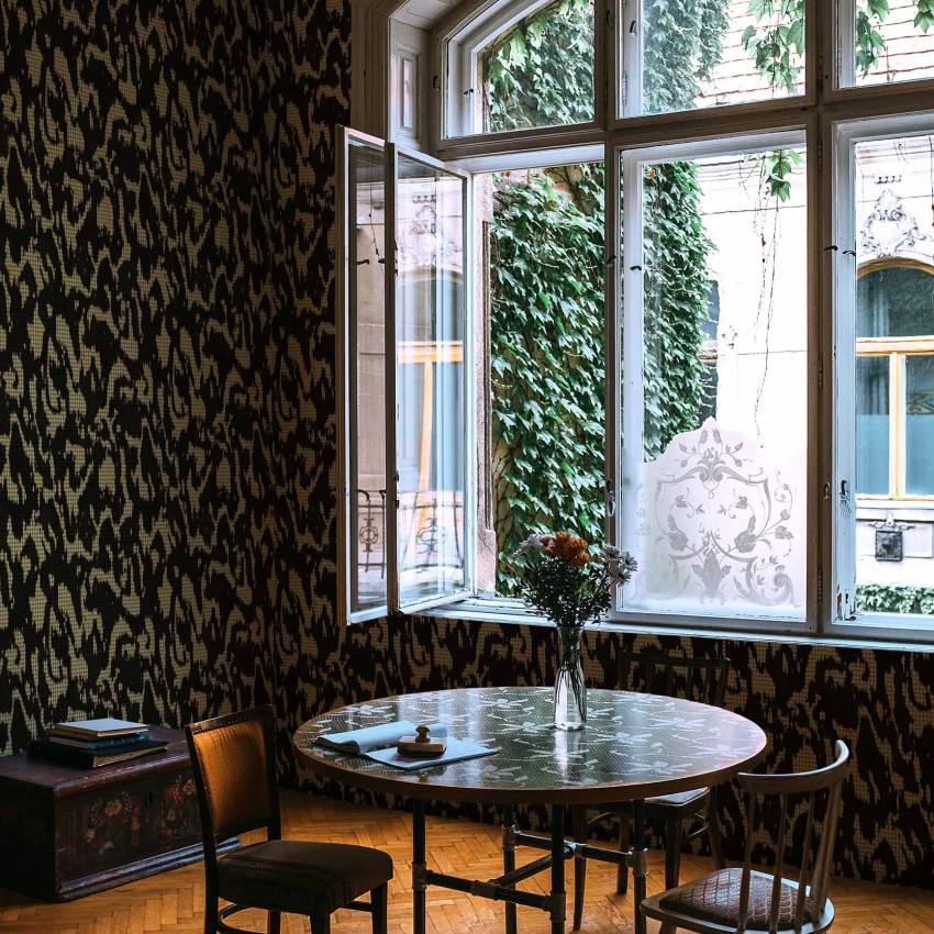 Tapet lavabil Moire Screen, negru, cu un model abstract inedit, decorand un perete accent din casa.