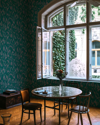 Tapet lavabil Moire Screen, verde, cu design abstract elegant. In imagine se vede un living decorat cu tapetul.