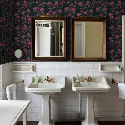 Tapet lavabil Blooming Damask, cu model floral Damasc, in nuante de fuchsia si verde, pe un perete din baie.