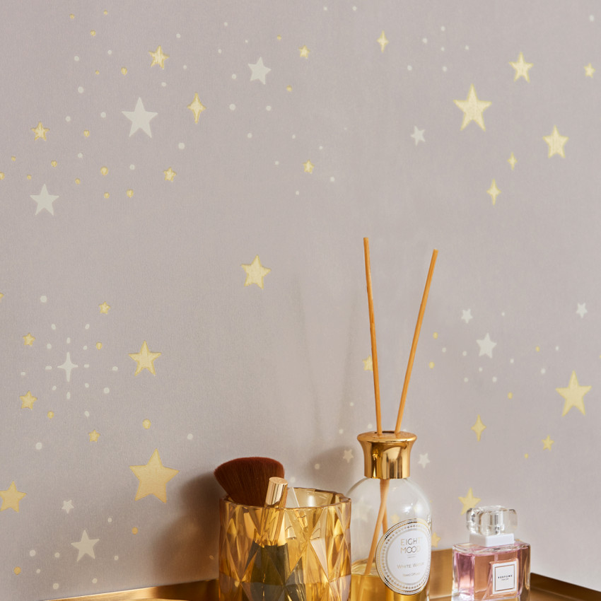Tapet Twinkle Mud Grey, cu stelute aurii si albe pe un fond gri deschis.