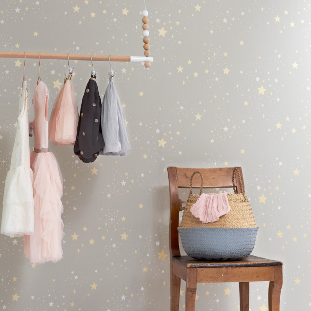 Tapet Twinkle Mud Grey, cu stelute aurii si albe pe un fond gri deschis.