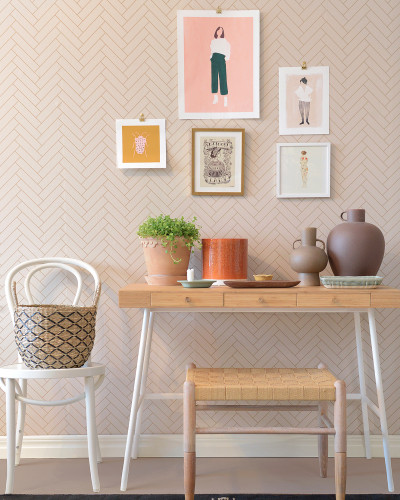 Tapet cu model herringbone în nuanțe de bej nisipos, decorat cu tablouri și plante. Tapetul este perfect pentru a crea un ambient elegant și modern.