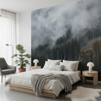 Fototapet personalizat cu o pădure densă pe un versant muntos, învăluită în ceață densă, într-un dormitor modern cu pat alb și noptiere din lemn.
