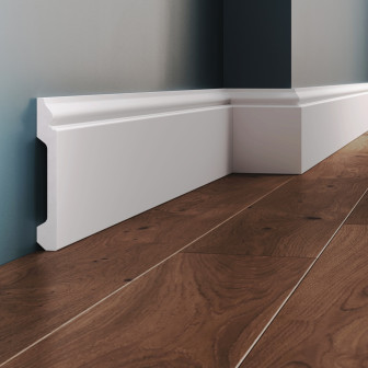 Plintă decorativă din polimer rigid, albă, montată pe perete și pardoseală din lemn